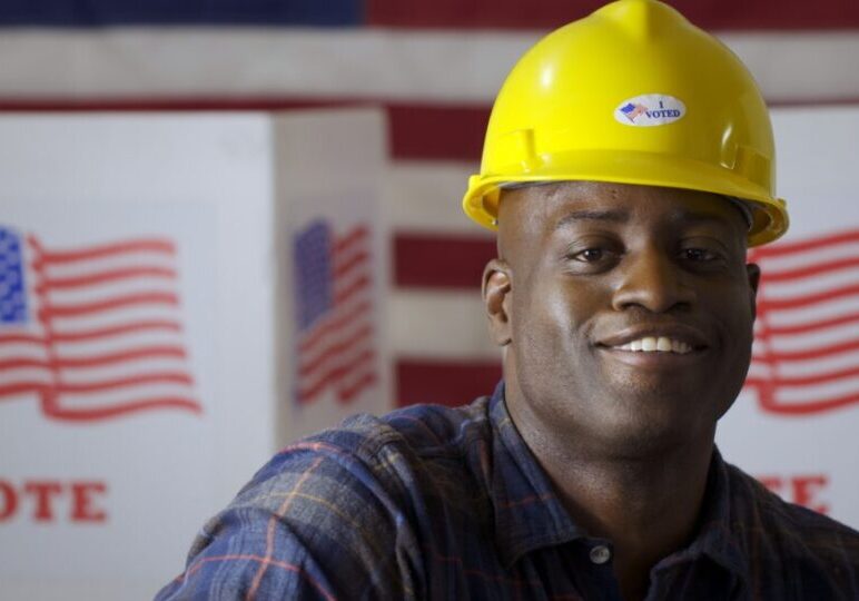 Close up African American man in plaid shirt wearing hard hat wi